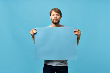 a man with a beard holding a blue background, a free place