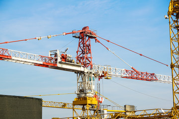 Part of yellow construction tower crane arm against blue sky