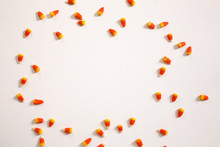 Candy Corn Frame Against A White Background Top View Flat Lay, Modern Halloween Concept With Copy Space