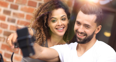 Poster - Happy cheerful couple sitting down at a cafe and making selfie