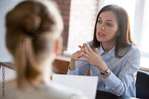 Fotomural Confident focused businesswoman, teacher or mentor coach speaking to business pe