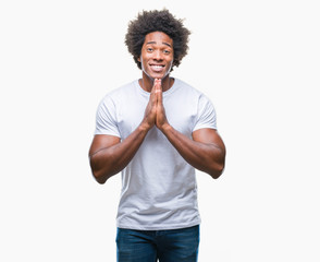 Sticker - Afro american man over isolated background praying with hands together asking for forgiveness smiling confident.