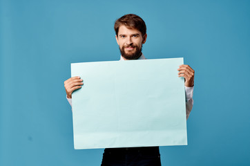 man with a sheet of paper on a blue background