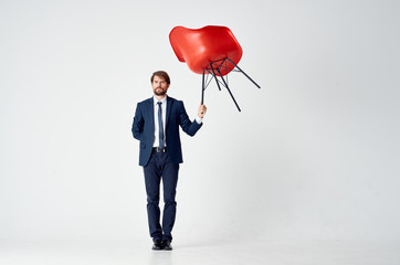 Poster - a man holds a red chair in one hand