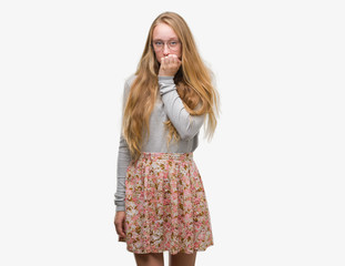 Poster - Blonde teenager woman wearing flowers skirt looking stressed and nervous with hands on mouth biting nails. Anxiety problem.