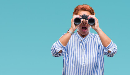 Sticker - Senior caucasian woman looking through binoculars over isolated background scared in shock with a surprise face, afraid and excited with fear expression