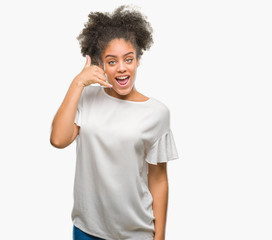 Young afro american woman over isolated background smiling doing phone gesture with hand and fingers like talking on the telephone. Communicating concepts.