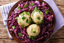 Delicious potato dumplings with stewed red cabbage close-up on a plate. horizontal top view from above