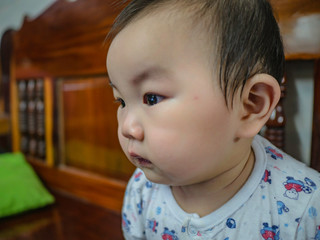 Cutie and handsome asian boy baby or infant make a face like interested with something