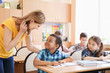 © Africa Studio - Female teacher helping boy with his homework in classroom at school