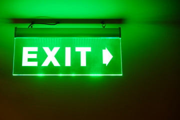 Front face raised view of green emergency fire exit sign hanging on the ceiling