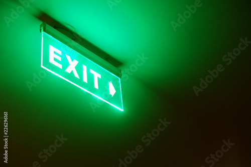 Perspective View Of Green Emergency Fire Exit Sign Hanging On The