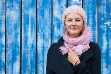 Wall Mural - Portrait female student on bright background. Beautiful modern urban young woman wearing pink knitting hat  smile, look at the camera and engoy autumn sunny day.