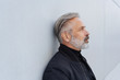 © contrastwerkstatt - Mature thoughtful bearded man standing by wall