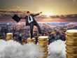 © Nomad_Soul - Businessman on stacks of coins, financial balance