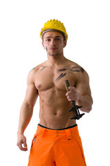 Wall Mural - Muscular young construction worker shirtless with hardhat, isolated on white background, looking at camera