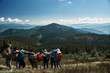 © Yakobchuk Olena - Rear view of young active tourists bonding to each other while enjoying a beautiful scenery from the mountain hill