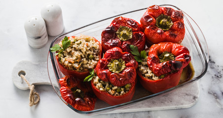 Wall Mural - banner of ready baked stuffed peppers in a glass baking dish on white marble table. healthy vegan cuisine for the whole family. comfort food