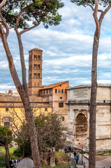 Wall Mural - View on ancient cathedral between the trees with blue cloudy sky on the background