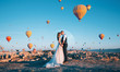 © Mykhailovskyi - bride and groom on the background of the moon and balloons flying over the valley of love