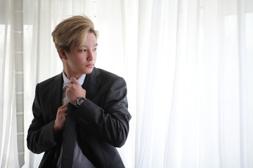 Wall Mural - Young Asian businessman in white shirt and tie