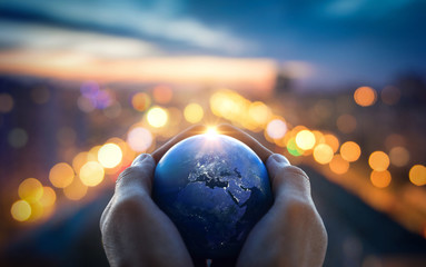 The globe Earth in the hands of man against the night city. Concept on business, politics, ecology and media. Elements of this image furnished by NASA