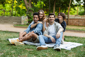 Sticker - Young friends outdoors in park having fun posing drinking soda.