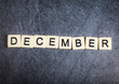 Letter tiles on black slate background spelling December