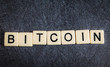 Letter tiles on black slate background spelling Bitcoin