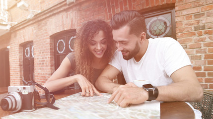 Poster - Couple in an outdoor cafe using map and planning itinerary