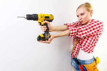 Woman using drill on wall