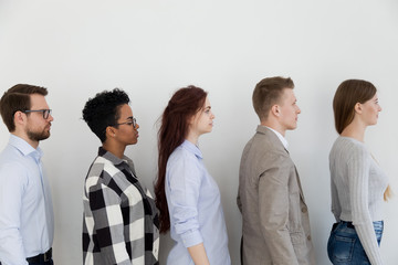 Wall Mural - Diverse people standing in row opposite wall in queue wait job interview or examination. All person students serious feels confidents. Competition company position. Human resources recruiting concept