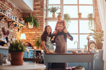 Wall Mural - Mom dad and little daughter together in loft style kitchen at morning.