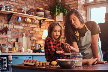 Wall Mural - Happy mom cooking with her little daughter in loft style kitchen at morning.