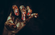 Bloody dirty zombie hand on black background. Halloween spooky poster
