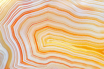 Amazing Yellow Banded Agate Crystal cross section as a background. Natural light translucent agate crystal surface, Orangy abstract expressive structure slice mineral stone macro closeup