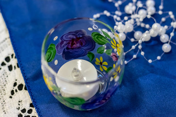 glass with flowers, blue background, closeup