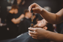 Barber Applies Beard Oil With Dropper For Man In Barbarshop.