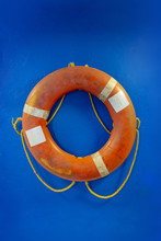 Overboad Saver Orange White With Yellow Rope Hanging On Blue Painted Wall