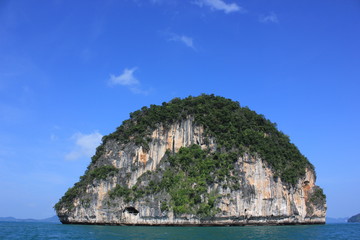 The uninhabited round shape island on the ocean with bright blue sky  