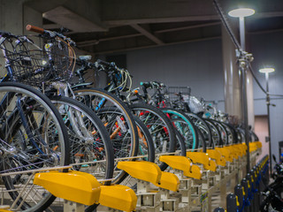 two rows system of bicycles parking indoor garage near the shinjuku train station. they be designed 