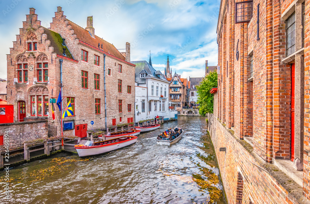 Boat trip on canal of Bruges. Popular for tourists who visit Belgium. - obrazy, fototapety, plakaty 