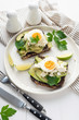 Wholegrain toast with avocado, egg and soft cheese on white plate, healthy breakfast healthy eating concept