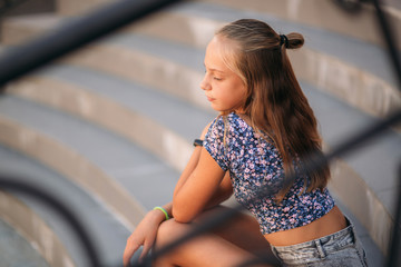 Wall Mural - teenage female dressed in jeans sits on stairs