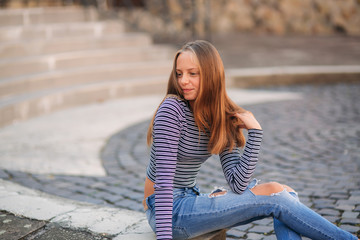 Wall Mural - young teenage poses for photo. blonde girl in jeans and blouse