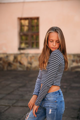 Wall Mural - young teenage poses for photo. blonde girl in jeans and blouse