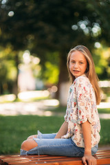 Wall Mural - young teenage girl sits on the bench