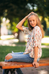 Wall Mural - young teenage girl sits on the bench