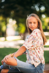 Wall Mural - young teenage girl sits on the bench
