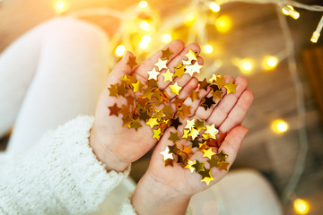 Golden stars sparkling on child's hands and palms.